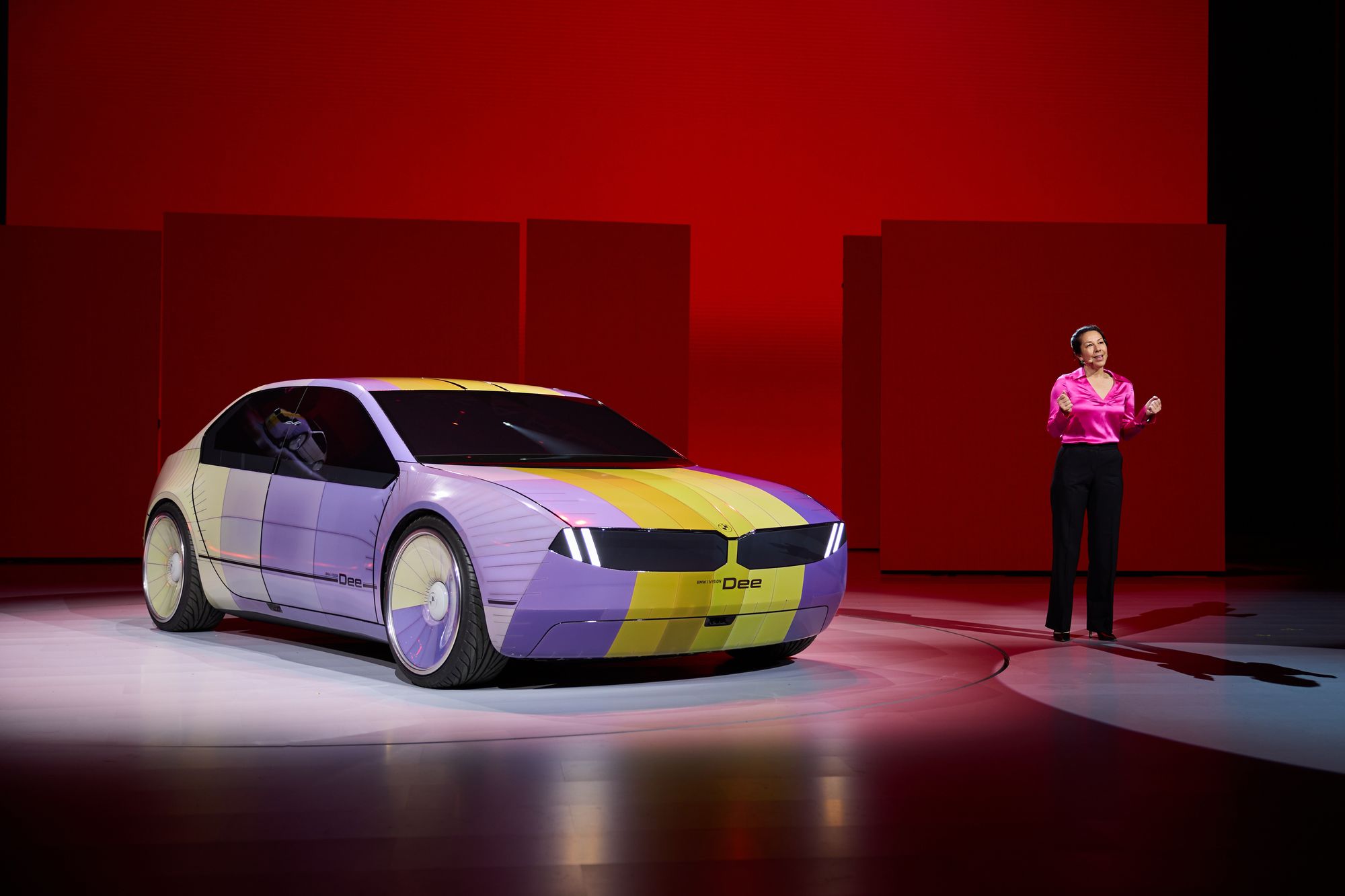A BMW executive standing in front of the i Vision Dee color changing car. 