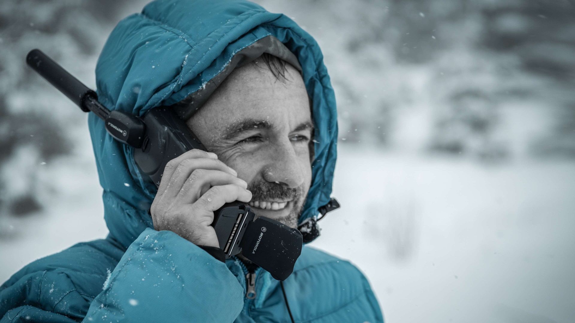 A person talking on a bulky satellite phone.