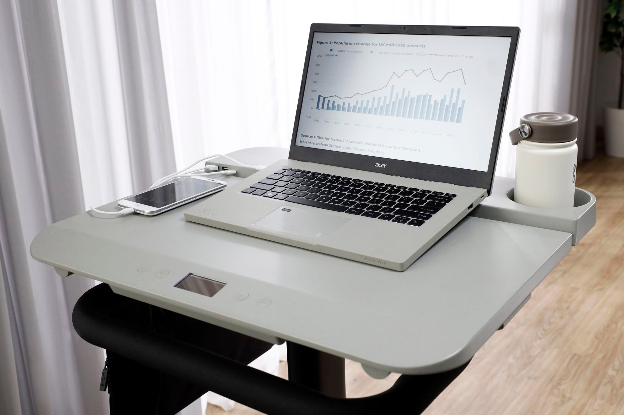 A laptop and a phone sitting on the table section of the Acer eKinekt BD 3.