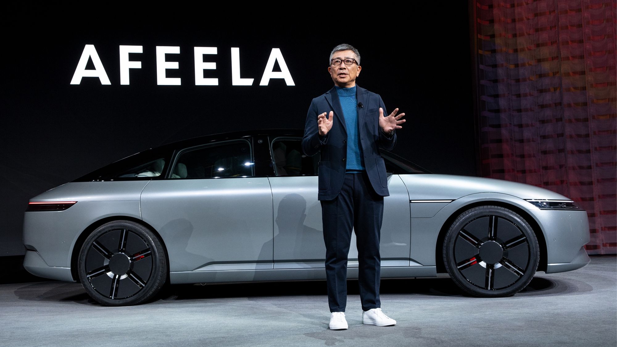  A company executive standing in front of the Sony Afeela car concept. 