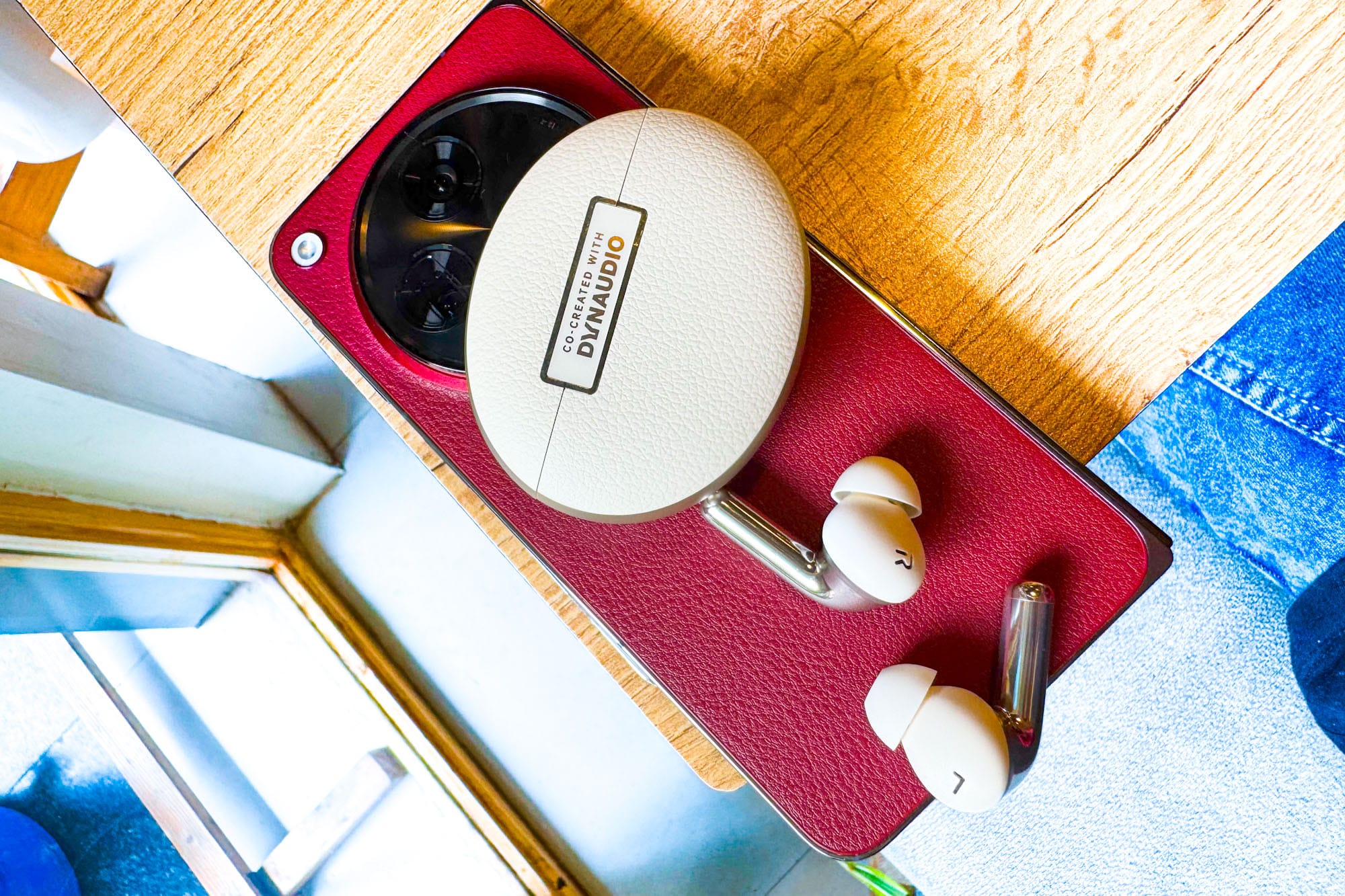 OnePlus Buds Pro 3 wireless earbuds with a OnePlus Open in red.