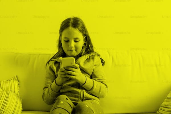 A girl staring at a phone's screen.
